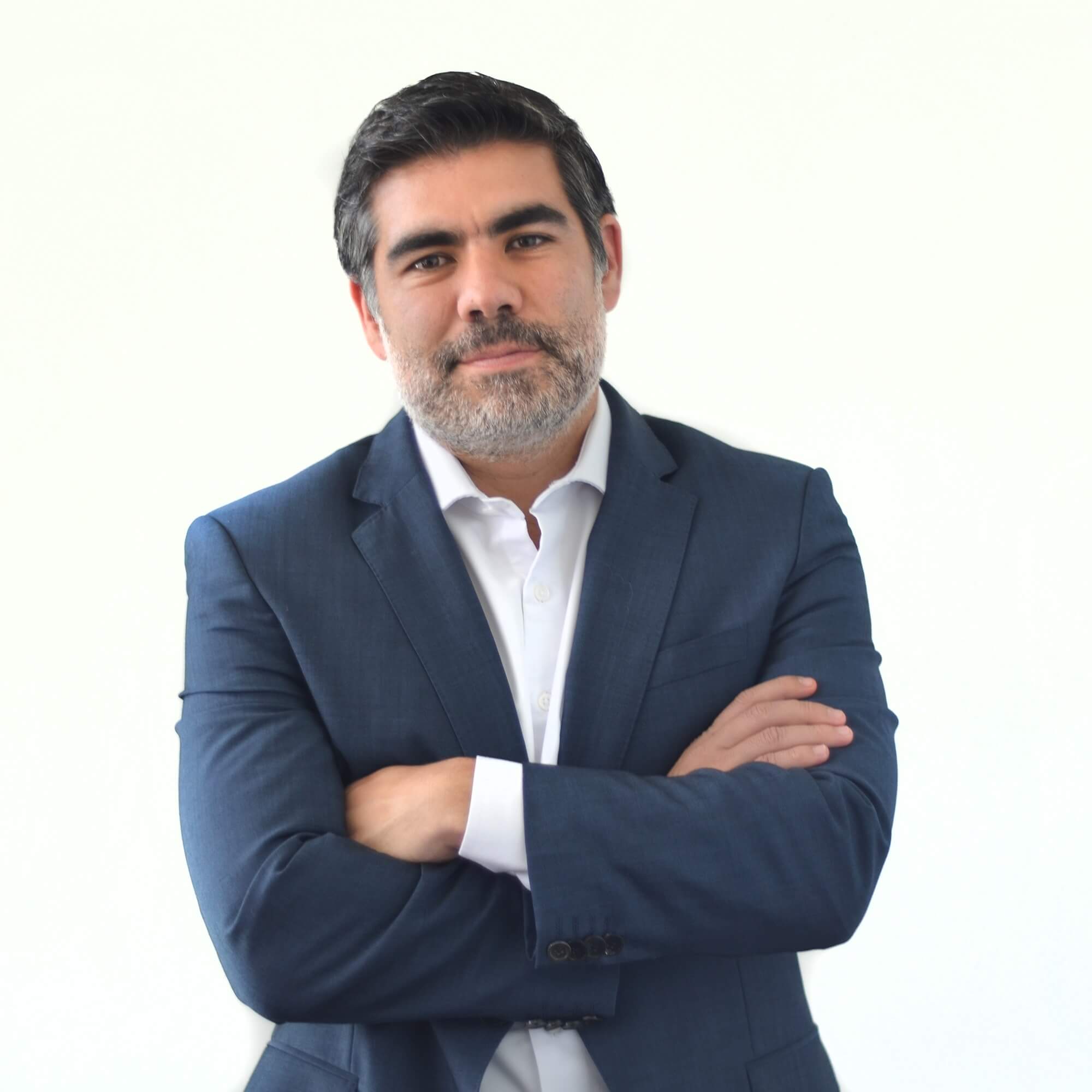 Persona de pie con traje azul y brazos cruzados.