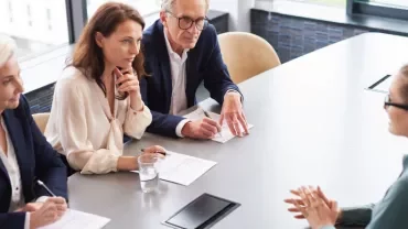 Entrevista de trabajo en oficina moderna con mesa alargada.