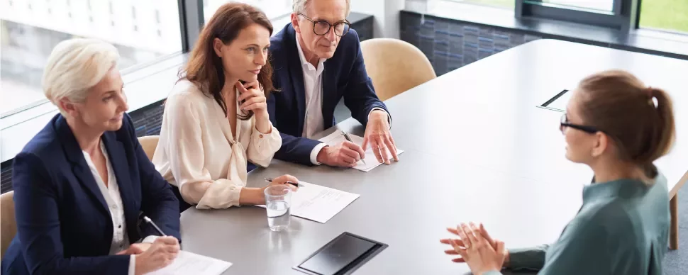 Entrevista de trabajo en oficina moderna con mesa alargada.