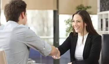 Dos personas dan la mano en una oficina.