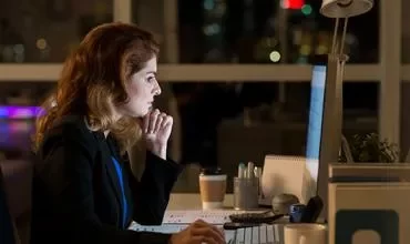 Persona trabajando en una computadora en una oficina por la noche.