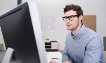 Persona mirando un monitor en una oficina moderna.