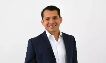 Persona sonriendo vistiendo un traje azul.