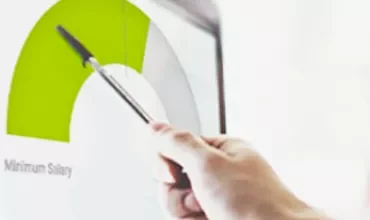 Persona señalando un gráfico de barra verde en una pantalla.