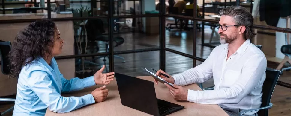 Dos personas conversando en una oficina moderna.