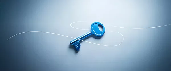 Llave azul sobre superficie clara, representando acceso y soluciones estratégicas.
